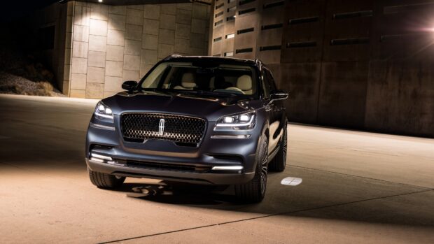 A Lincoln car is parked in a modern concrete setting with lights on at night, 4K Desktop Wallpaper
