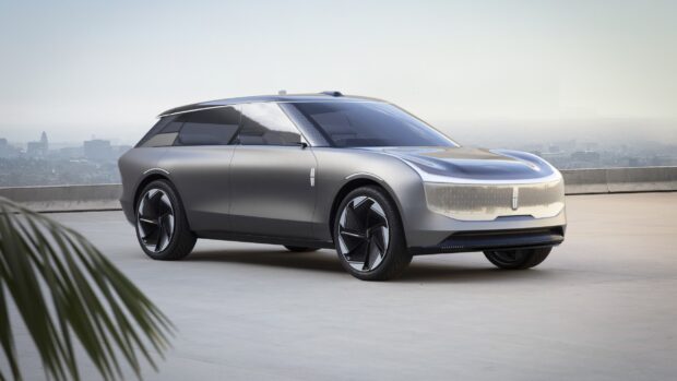 A sleek Lincoln car is parked outdoors with a city skyline in the background, 2K Desktop Wallpaper