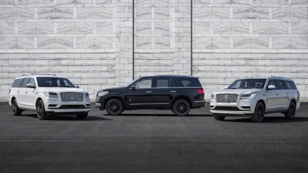 A lineup of Lincoln cars featuring black and white models against a stone wall backdrop, 4K Desktop Wallpaper