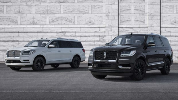 Two Lincoln SUVs in black and white are parked against a stone wall, 4K Desktop Wallpaper
