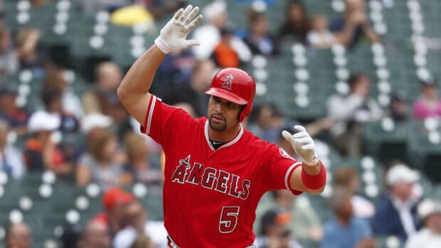 A Los Angeles Angels player wearing a red uniform raises his hands during a game, 4K Desktop Wallpaper