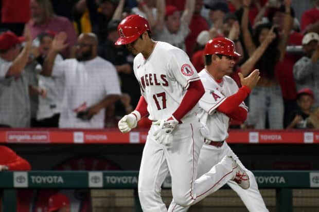 A Los Angeles Angels player celebrates on the field with a coach clapping behind him, 2K Desktop Wallpaper
