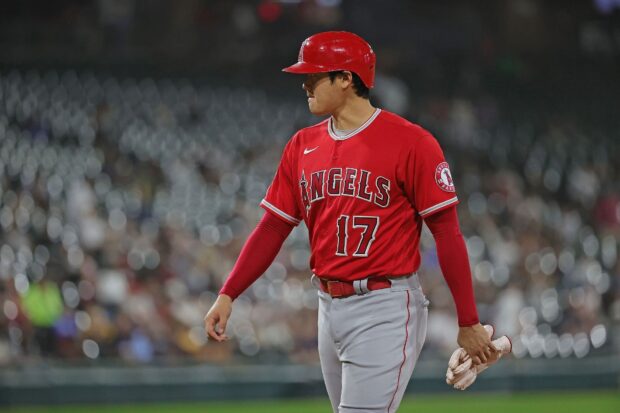 A Los Angeles Angels player in red uniform is walking on the baseball field during the game, HD Desktop Wallpaper