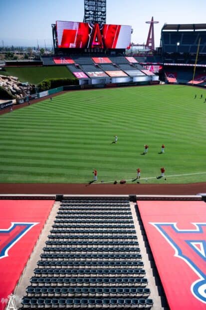 The Los Angeles Angels players are warming up on the field under a clear sky, HD Phone Wallpaper
