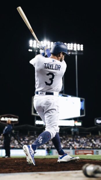 A Los Angeles Dodgers player is swinging the bat during a night game, HD Phone Wallpaper