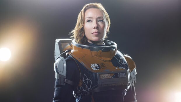 A woman in a futuristic space suit from Lost In Space TV series looks determined, 4K Desktop Wallpaper