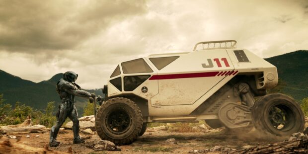 An alien stands beside a rugged vehicle in the Lost In Space tv series scene, 2K Desktop Wallpaper