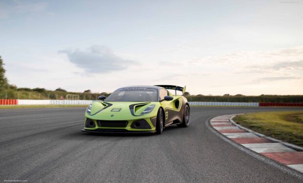 A green Lotus Emira is driving on a race track with clear skies in the background, 2K Desktop Wallpaper