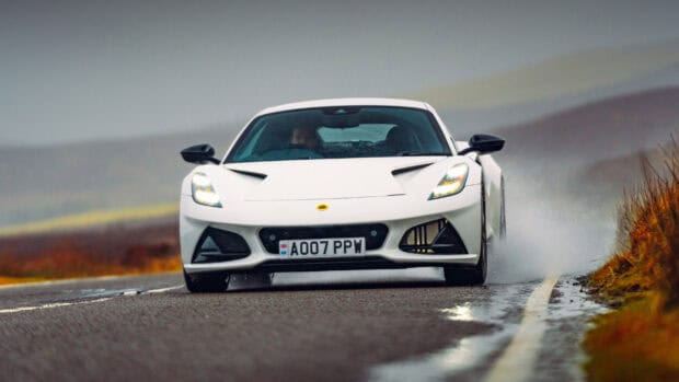 A white Lotus Emira drives on a wet winding road with water splashing, 2K Desktop Wallpaper