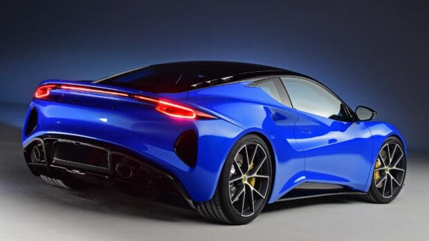 The Lotus Emira is shown in a striking blue color with illuminated tail lights, HD Desktop Wallpaper