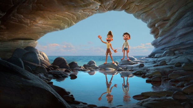 Luca Wallpapers showing two boys standing near a reflective water pool inside a cave opening by the sea, 2K Desktop Wallpaper