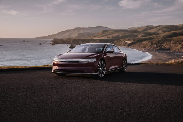 A Lucid Motors car is parked near the ocean with hills in the background, 2K Desktop Wallpaper
