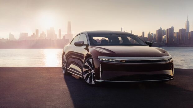 A Lucid Motors car is parked by the water with the city skyline in the background at sunset, HD Desktop Wallpaper