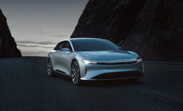 A sleek Lucid Motors electric car is parked on a mountain road at dusk, 2K Desktop Wallpaper