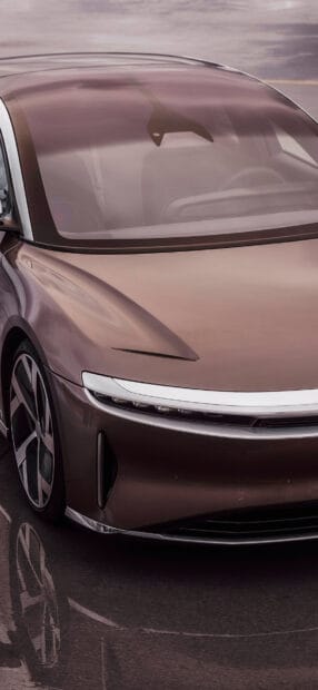 A sleek Lucid Motors electric car is parked on a reflective surface with a futuristic design, HD Phone Wallpaper