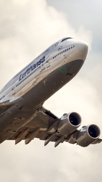 A Lufthansa Boeing 747 aircraft flying through a cloudy sky, HD Phone Wallpaper