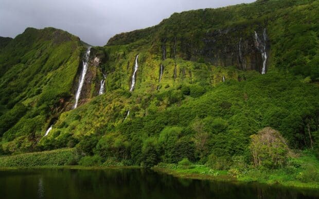 The Azores features lush green cliffs with several waterfalls flowing down into a calm lake, HD Desktop Wallpaper