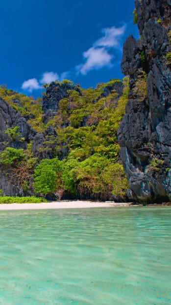 A peaceful beach scene with rocky cliffs and green trees in Palawan, HD Mobile Wallpaper