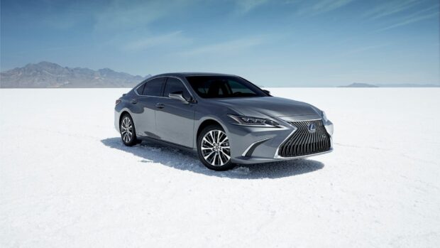 A sleek Lexus Es is parked on a vast snowy terrain with mountains in the distance, HD Desktop Wallpaper