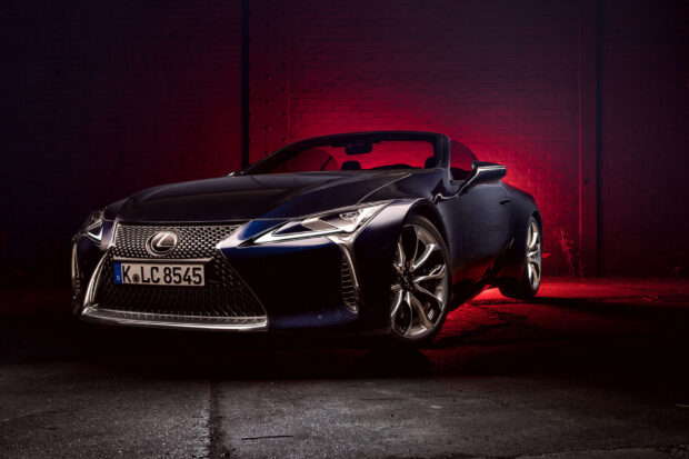 A sleek Lexus LC sports car is captured with dramatic red lighting on a dark urban background, 2K Desktop Wallpaper