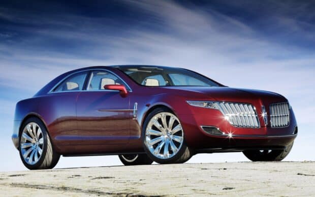 A red Lincoln car shines under the blue sky on a sandy ground, HD Desktop Wallpaper