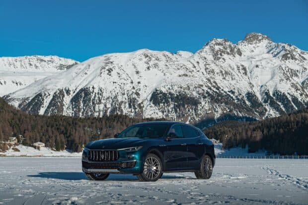 A Maserati Levante is parked on snow with mountains in the background, HD Desktop Wallpaper