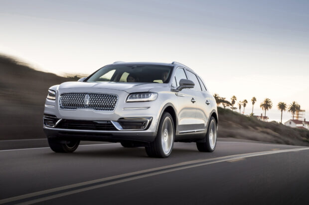 A silver Lincoln Nautilus driving on a road with palm trees in the background during sunset, HD Desktop Wallpaper