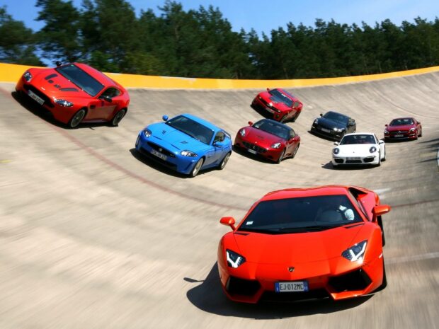 A group of luxury sports cars are driving fast on a steep curved race track during a sunny day, HD Desktop Wallpaper