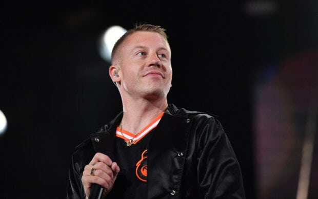 Macklemore is performing live on stage holding a microphone, 2K Desktop Wallpaper