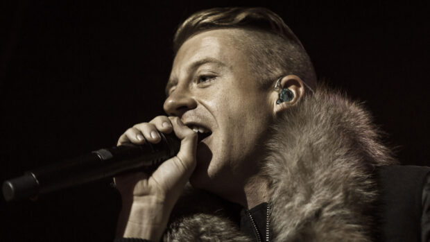 Macklemore is singing passionately into a microphone during a concert, HD Desktop Wallpaper