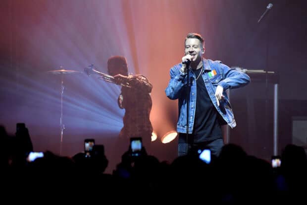 Macklemore is performing live in front of an audience with a trumpet player in the background, HD Desktop Wallpaper