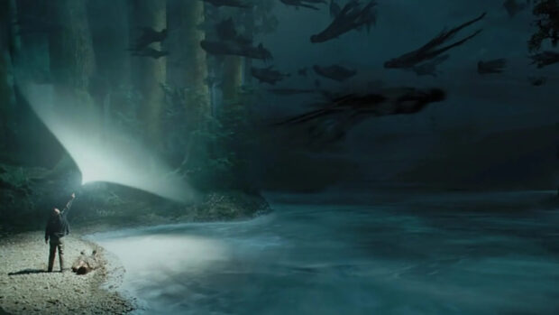 A wizard casts a Patronus charm to ward off Dementors near a river at night, HD Desktop Wallpaper