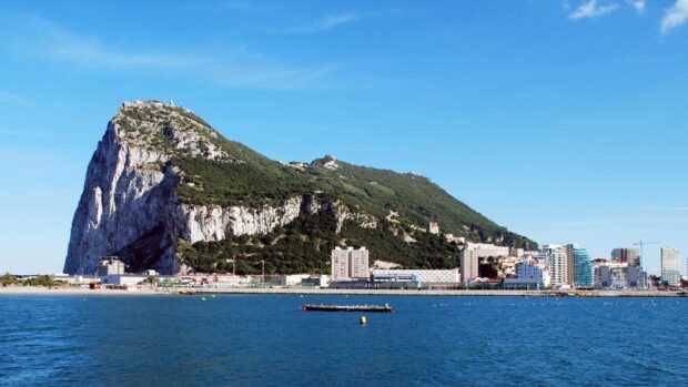 The Gibraltar Rock stands tall above the coastal city under clear skies, HD Desktop Wallpaper