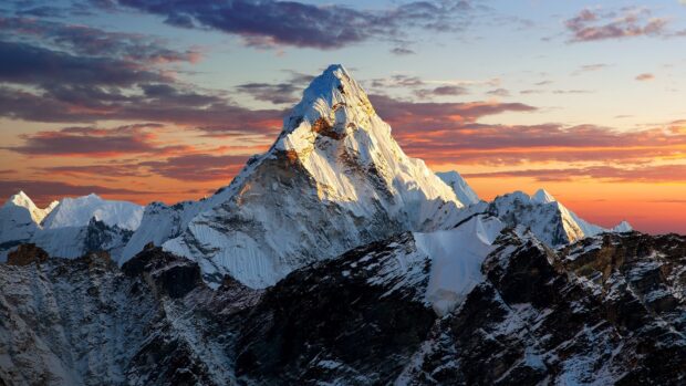 The Tibetan highlands show a snow covered mountain peak under a colorful sunset sky, HD Desktop Wallpaper