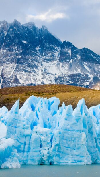 A stunning view of glacier ice formations near steep mountains featuring glacier wallpapers 4K and HD, 2K Mobile Wallpaper