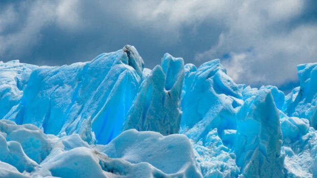 Majestic glacier ice formations under a cloudy sky showcasing glacier wallpapers, 4K Desktop Wallpaper