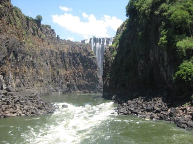 The Devils Pool in Zambia shows cascading waterfall between rocky cliffs, 2K Desktop Wallpaper