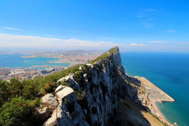 A stunning landscape of Gibraltar Rock overlooking the sea and city under blue sky, HD Desktop Wallpaper