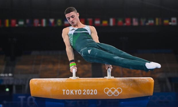 A male gymnast is executing a pommel horse routine during the Tokyo 2020 Olympics event, HD Desktop Wallpaper