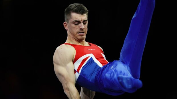 A male athlete is focused while executing a pommel horse gymnastics routine, 2K Desktop Wallpaper