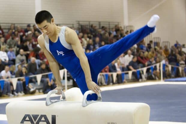 A male gymnast performing a pommel horse routine during a gymnastics event in front of a crowd, HD Desktop Wallpaper