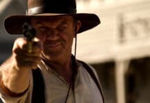 A man in a hat aiming a revolver with a focused expression in The Sisters Brothers, HD Desktop Wallpaper