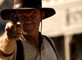 A man in a hat aiming a revolver with a focused expression in The Sisters Brothers, HD Desktop Wallpaper