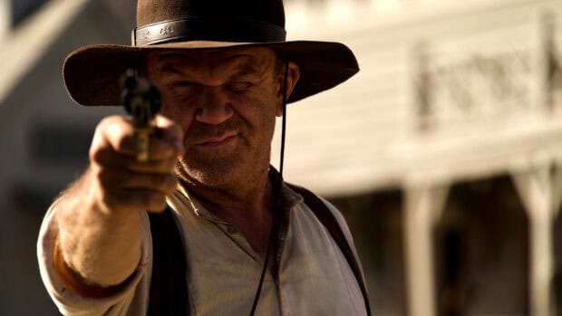 A man in a hat aiming a revolver with a focused expression in The Sisters Brothers, HD Desktop Wallpaper