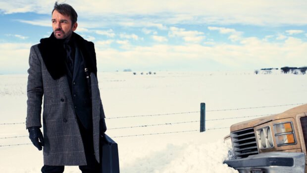 A man wearing a coat and gloves stands by a snowy field holding a briefcase under a blue sky in Fargo Wallpapers, HD Desktop Wallpaper