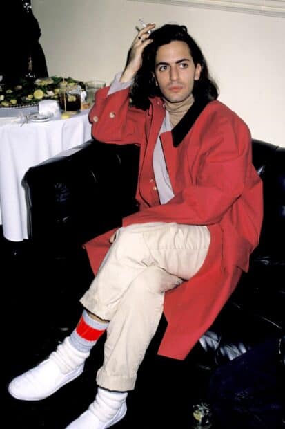 Marc Jacobs sits wearing a red coat and light pants while holding a cigarette, HD Mobile Wallpaper