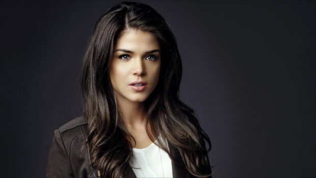 A close up portrait of Marie Avgeropoulos with long dark hair and green eyes wearing a jacket, 2K Desktop Wallpaper