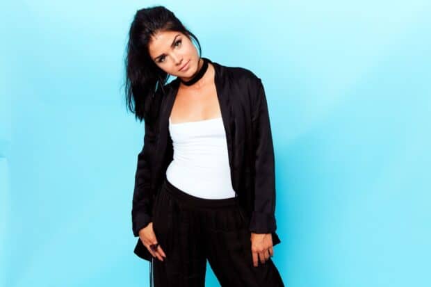 Marie Avgeropoulos is posing stylishly in black and white clothing with a blue background, HD Desktop Wallpaper