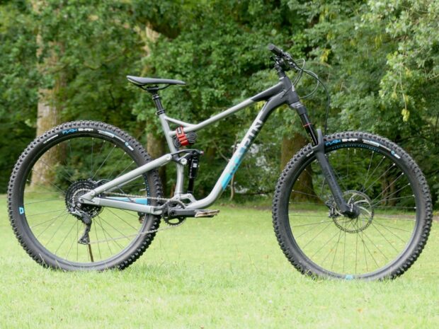 A grey Marin mountain bike stands on green grass with trees behind, HD Desktop Wallpaper