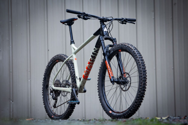 A detailed Marin Bikes mountain bike with dirt tires stands against a metal wall, HD Desktop Wallpaper